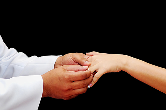 groom putting ring on bride's hand