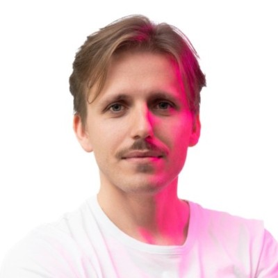 Portrait of a man with pink-toned lighting on a white background.